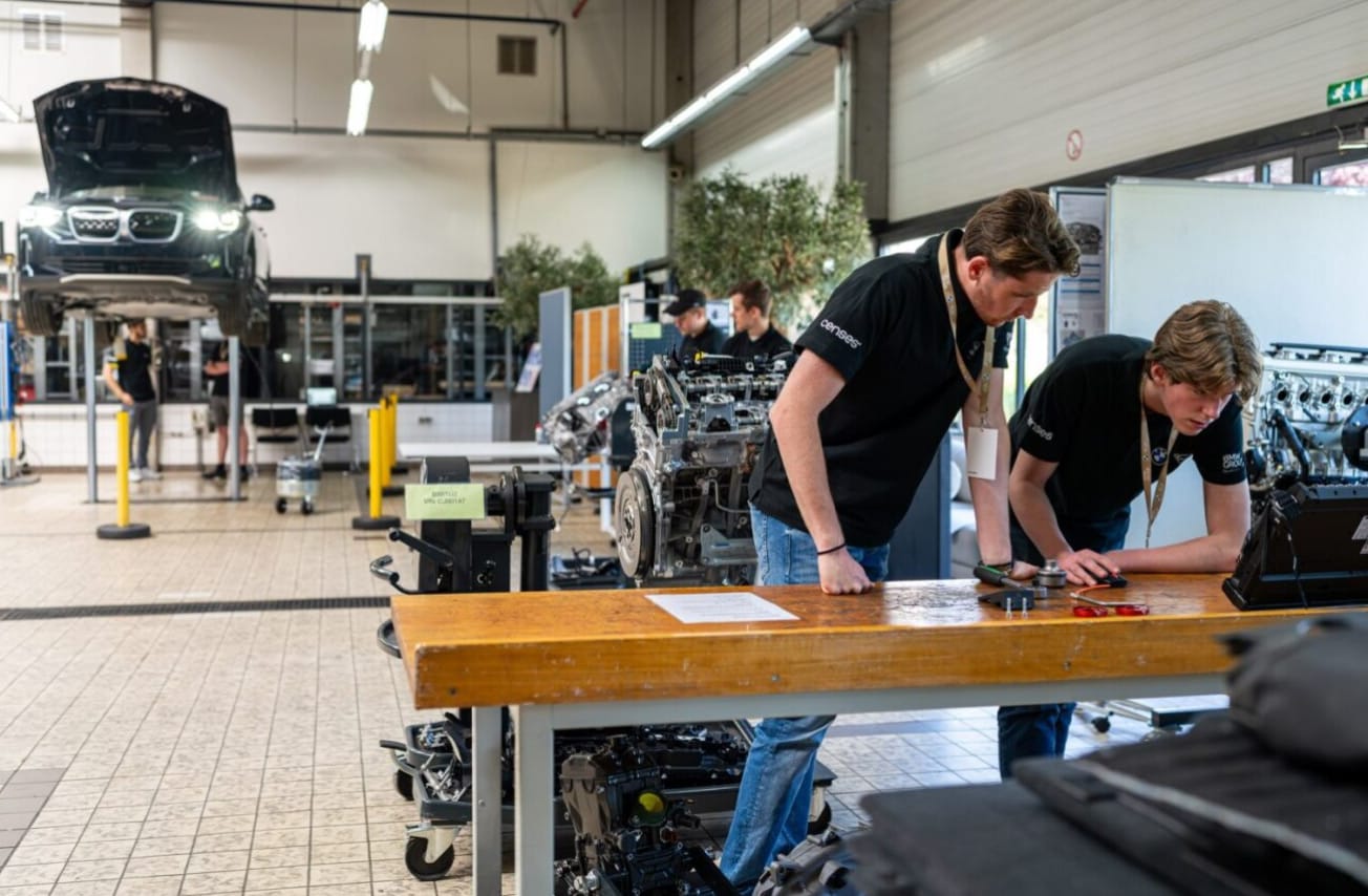 Cursisten in de werkplaats van BMW die een training volgen.